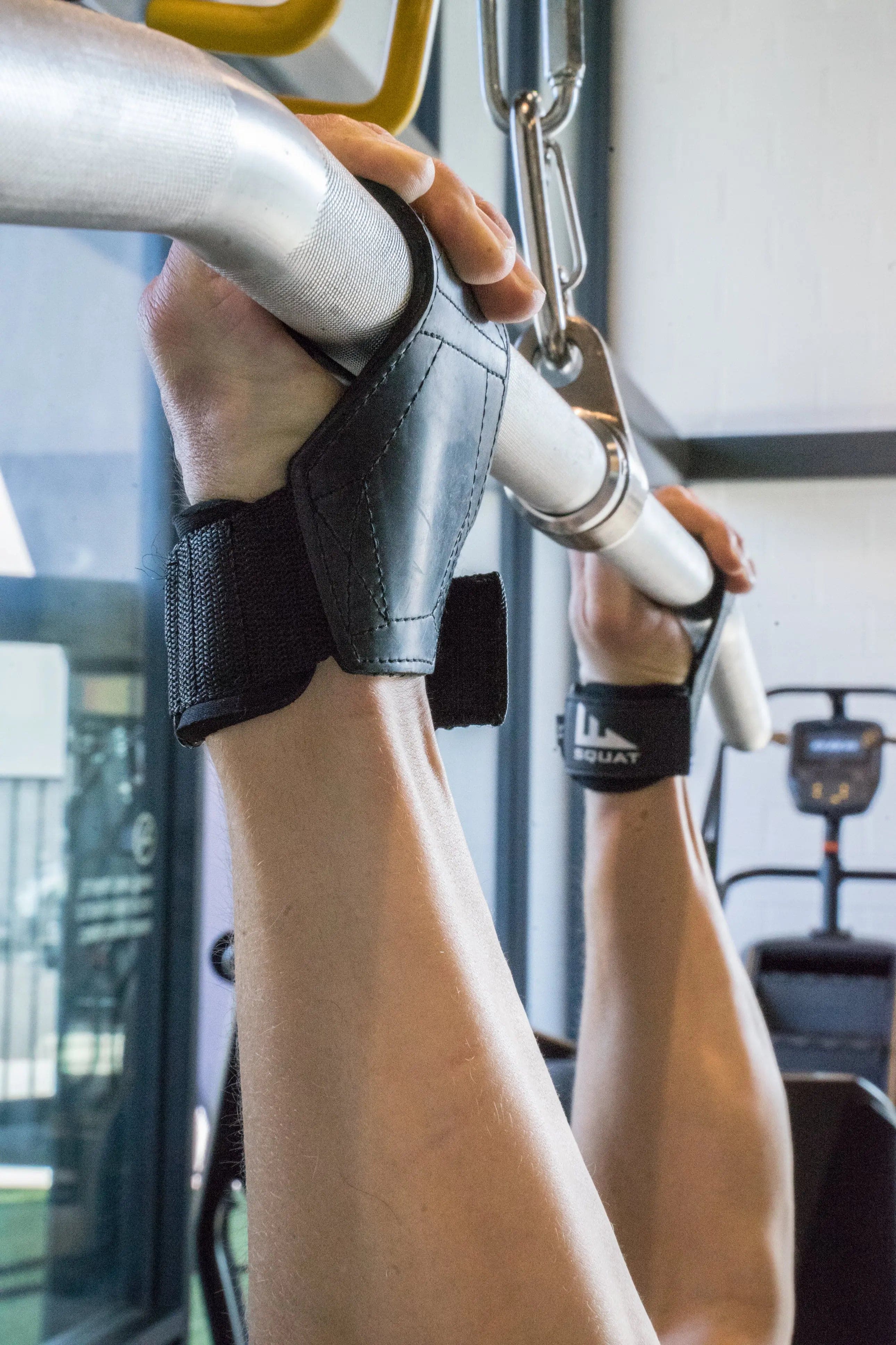 Person wrapping weightlifting straps around a barbell